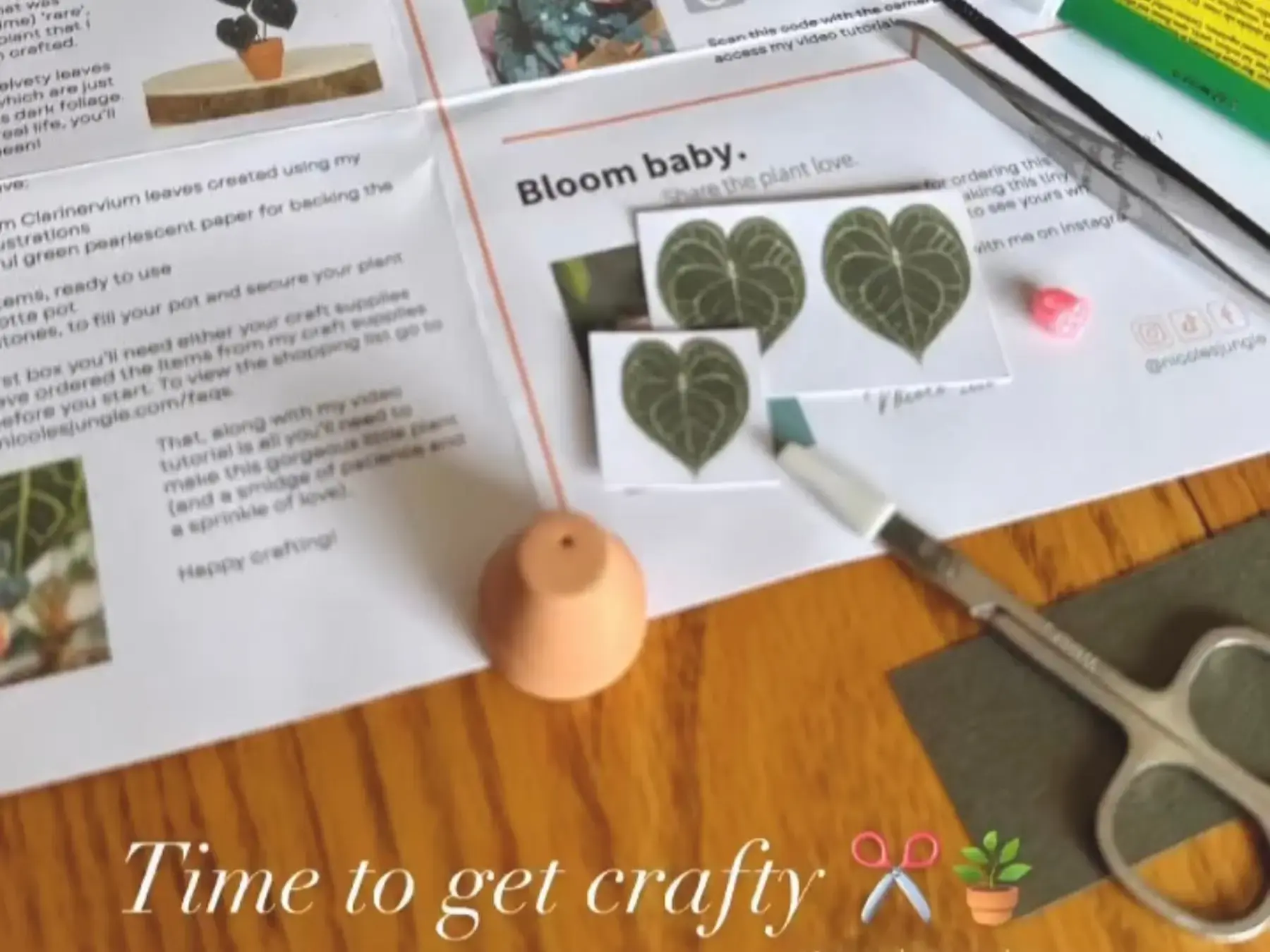 Paper plant leaves, tools, and instructions laid out for crafting
