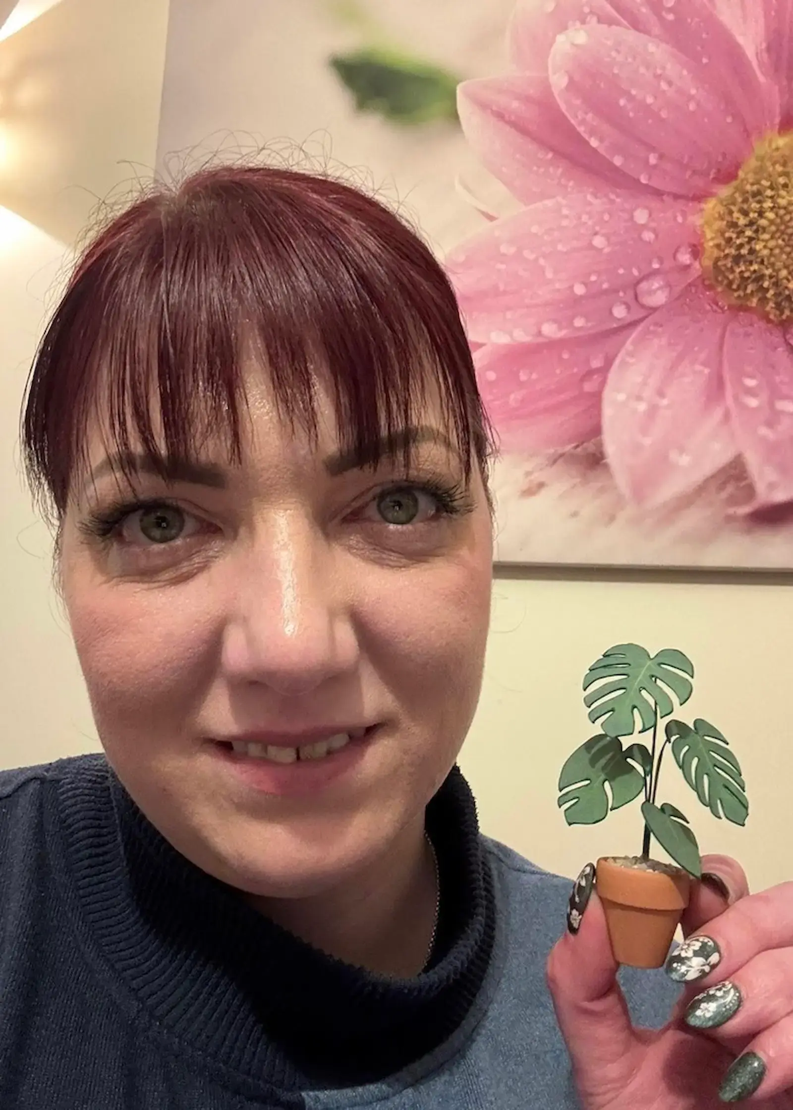 Customer holding a miniature paper Monstera in a terracotta pot