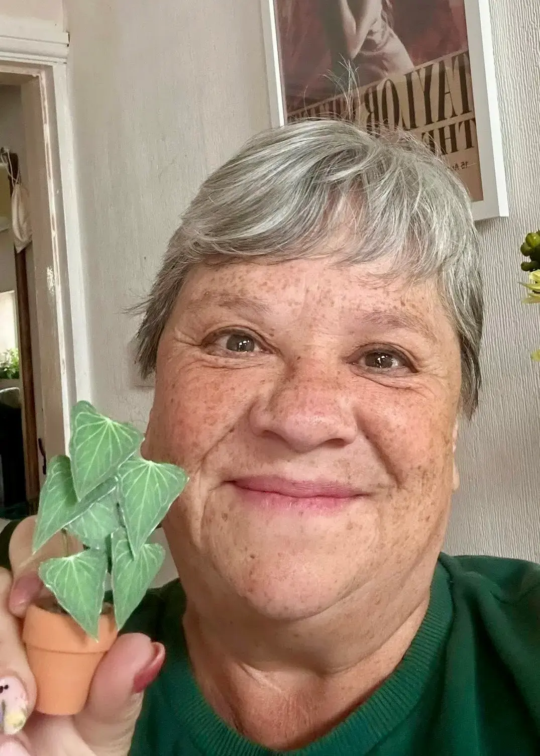 Customer holding a miniature paper Anthurium Delta Force in a terracotta pot