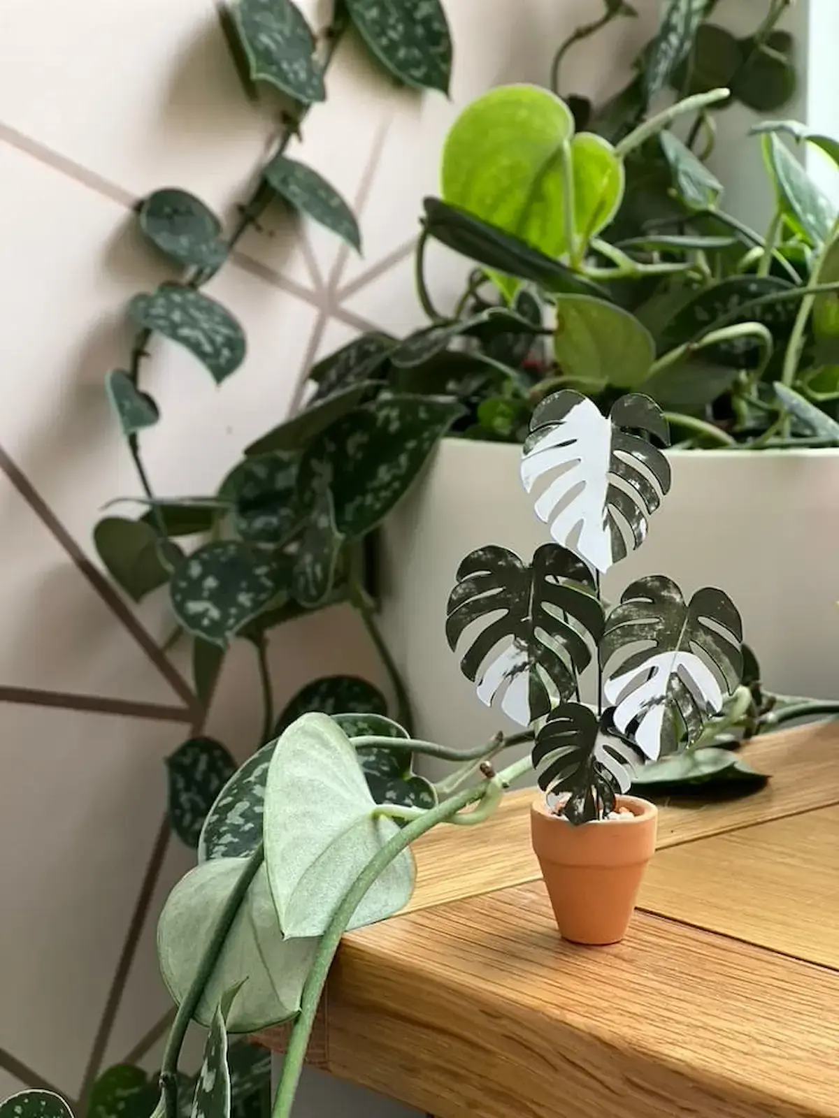 Miniature paper Monstera styled among real trailing houseplants